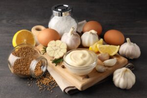 Concept of cooking garlic sauce on wooden background