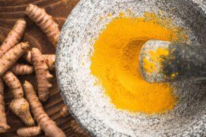 Tumeric powder superfood in granite pestle or mortar