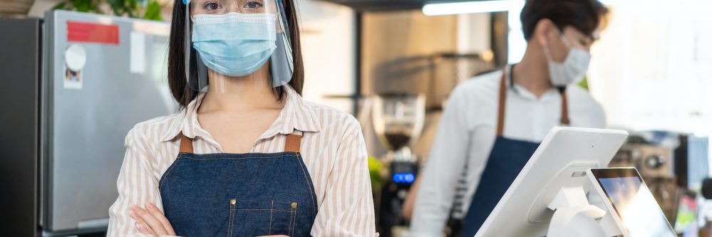 Portrait of attractive Caucasian waitress wearing protective mask to prevent from Covid-19