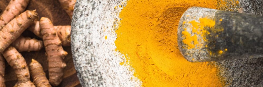 Tumeric powder superfood in granite pestle or mortar